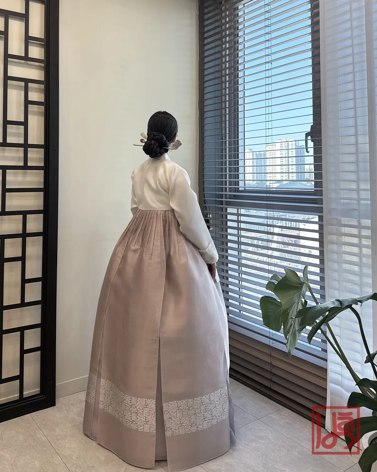 아이보리 저고리와 은은한 회분홍 치마에 금박 문양이 돋보이는 혼주 한복