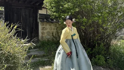 연노랑 저고리와 회청색 치마에 복(福) 문양 자수가 돋보이는 여성 한복