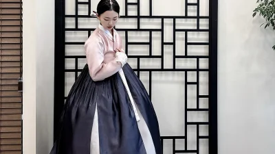 연분홍 저고리와 남색 치마로 우아함을 더한 성인 여성 한복