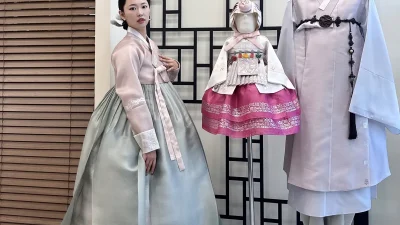 연분홍 저고리와 회청색 치마에 화문이 수놓인 성인 여성 한복