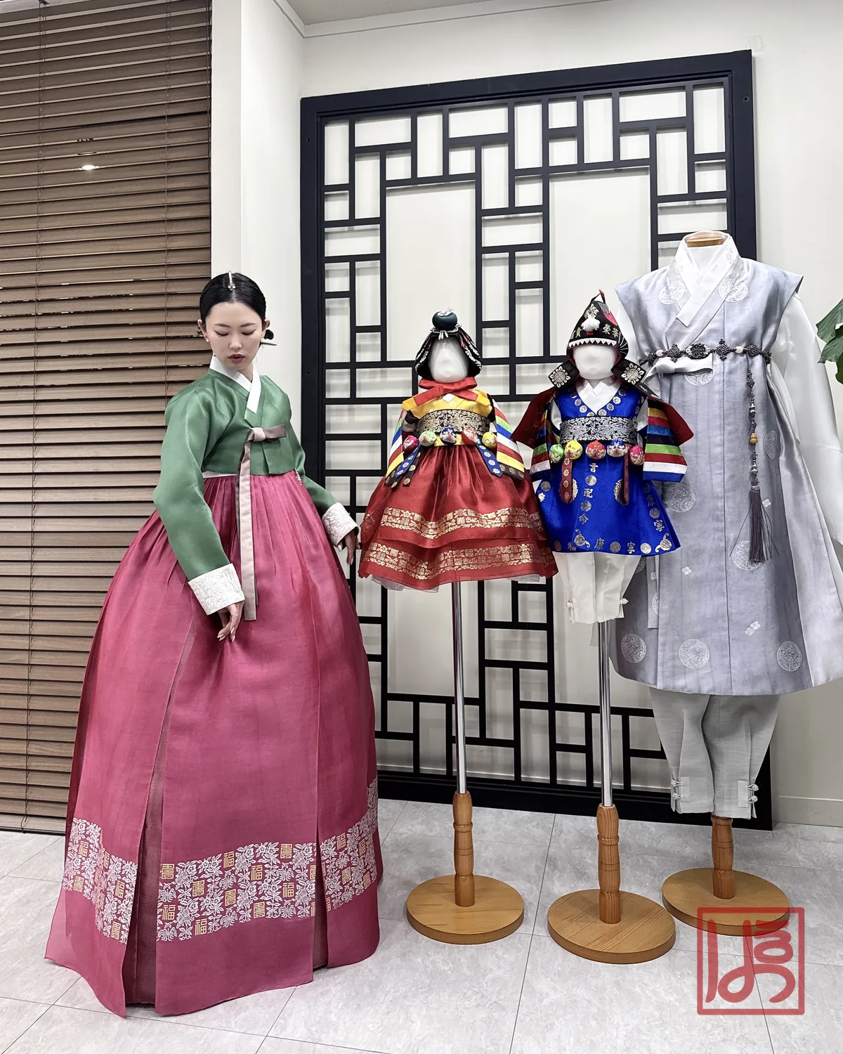 초록 저고리와 수복문 자주 치마의 한복이 매장에 전시된 돌한복들과 어우러진 모습