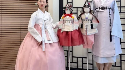 은은한 자수의 흰 저고리와 풍성한 연분홍 치마로 이루어진 여성 한복
