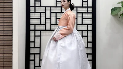 살구색 저고리와 아이보리 볼륨 치마로 이루어진 혼주 한복
