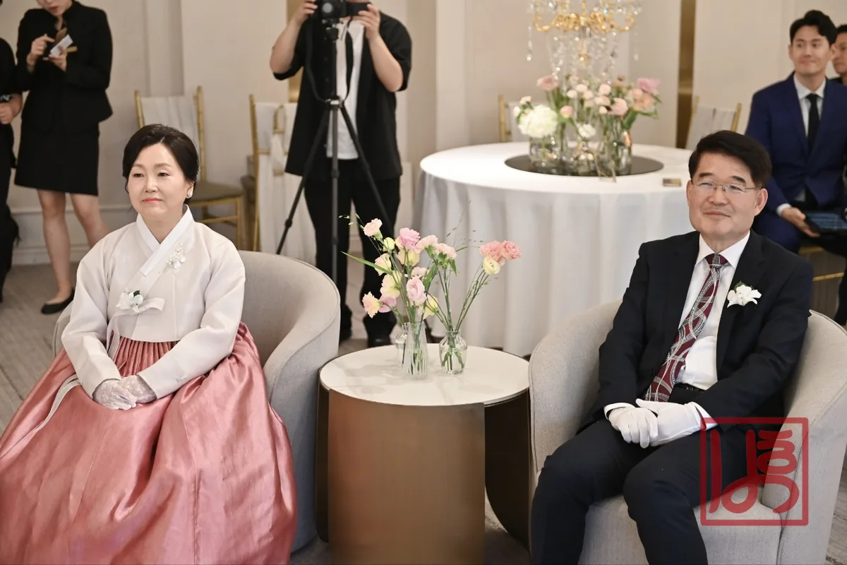 아이보리 저고리와 코랄빛 치마로 단아하게 갖춘 혼주 한복