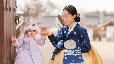 은장식 흉배와 자수가 화려한 남색 저고리와 황금색 치마의 당의 한복