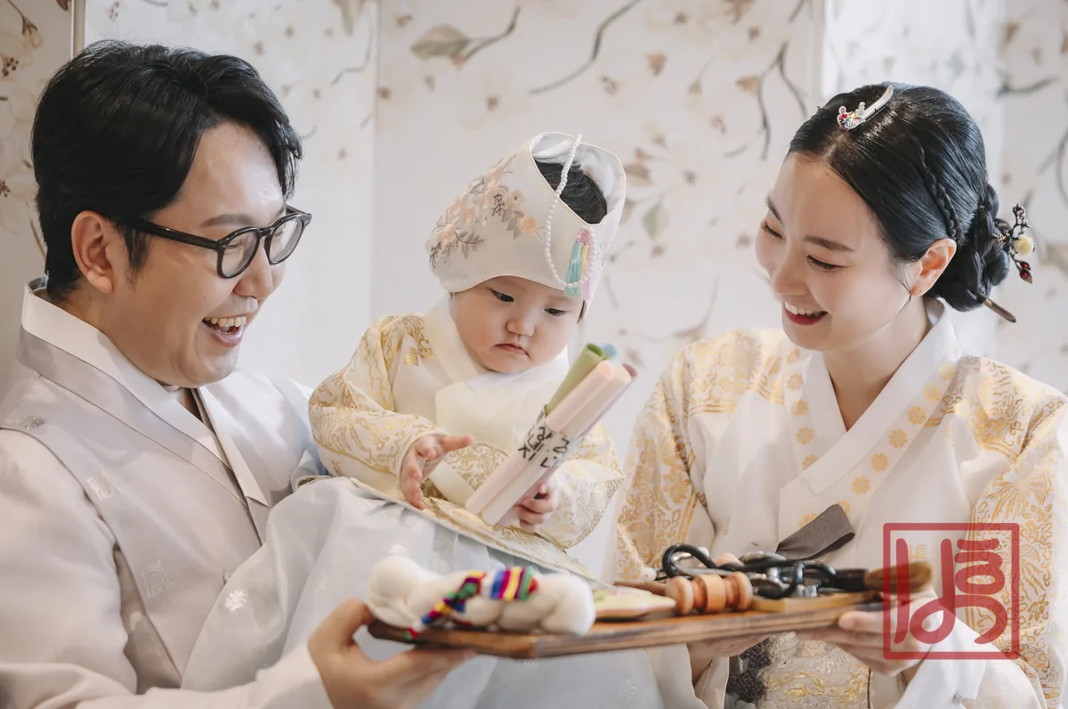 금색 꽃 자수 두루마기와 진주 장식 굴레를 갖춘 돌한복