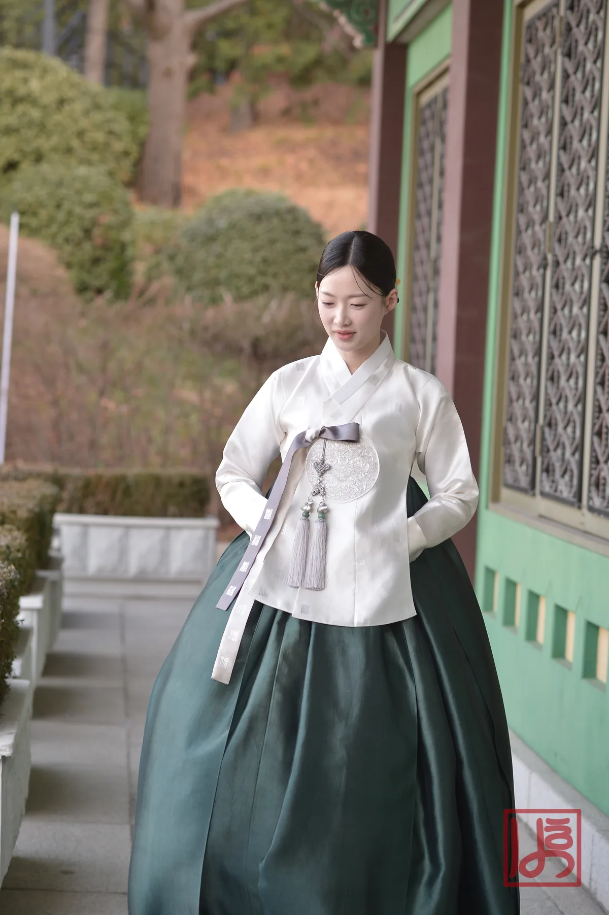 아이보리 저고리와 짙은 녹색 치마에 노리개를 더한 우아한 한복