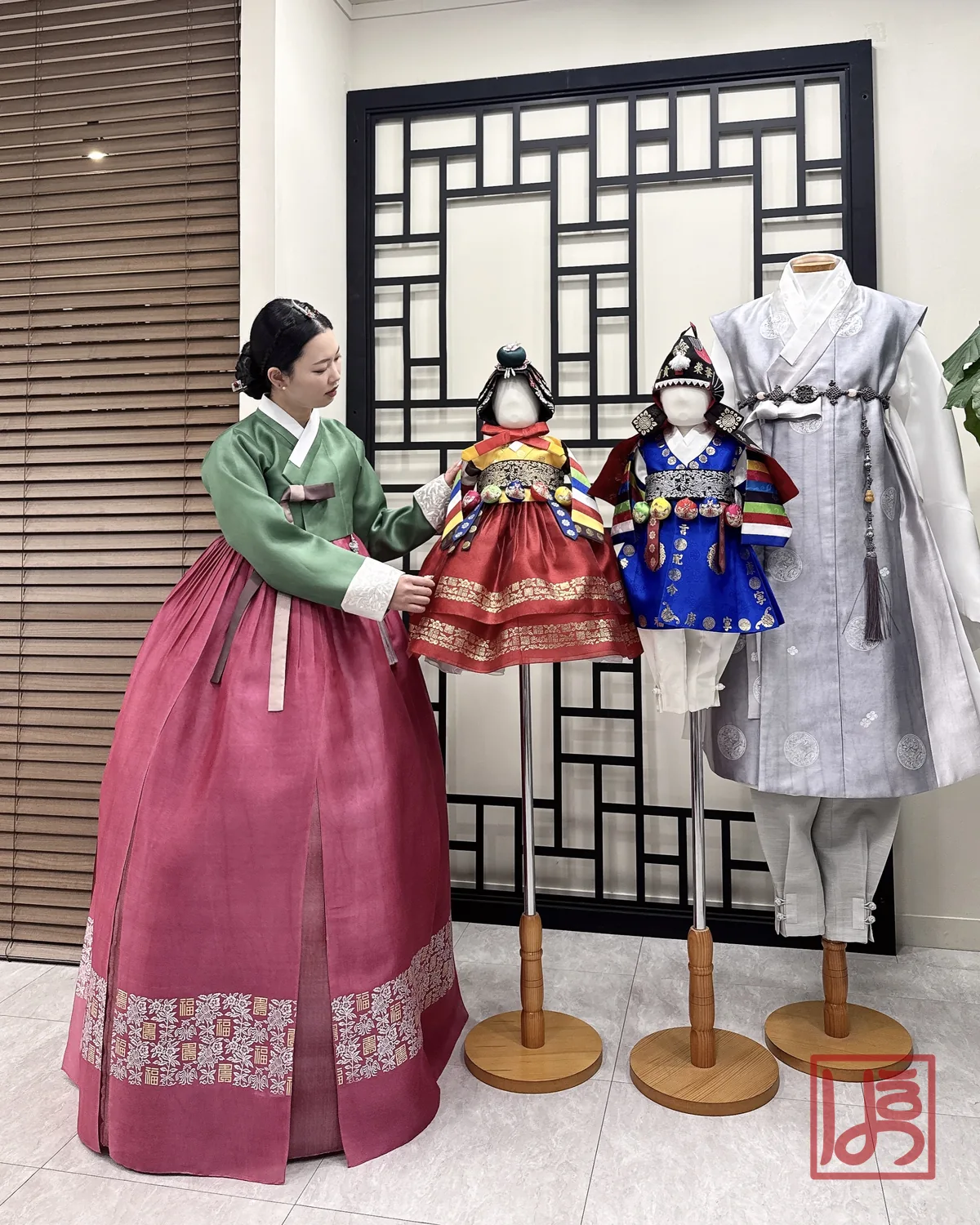 초록 저고리와 수복문 자주 치마의 한복이 매장에 전시된 돌한복들과 어우러진 모습
