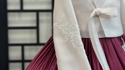 은장식 자수 소매의 아이보리 저고리와 자주색 치마로 이루어진 혼주한복