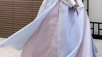 아이보리 저고리와 연분홍빛 그러데이션 치마가 우아하게 퍼지는 전통 한복