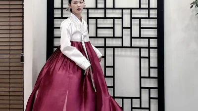 아이보리 저고리와 풍성한 자주빛 치마가 우아한 여성 혼주한복